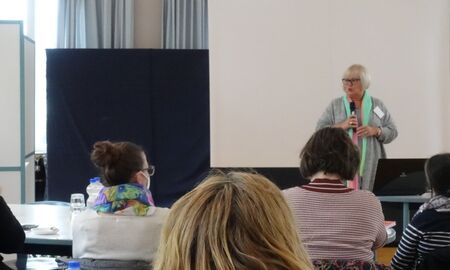 Die Abteilungsleitung der Grundschule Förderschwerpunkt Hören spricht in ein Mikrofon zum Publikum