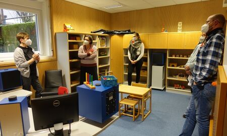 Eine Mitarbeiterin zeigt Interessenten die Pädaudiologische Beratungsstelle