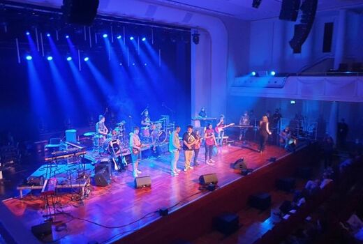 Blick auf ganze Bühne mit Band von schräg oben.