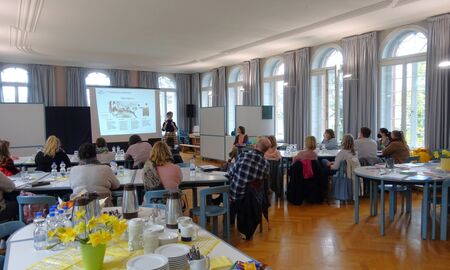 Eine Mitarbeiterin spricht vor Besuchern der Fortbildung