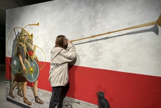 Illusion: Auf einem Bild gehen zwei römische Soldaten eine Straße entlang. Sie tragen jeder eine Cornu, eine kreisförmig gewundene Trompete. Ein Schüler im Vordergrund bläst in ein Lituus, eine römisches Signalhorn.