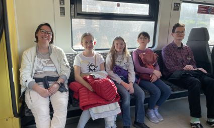 Zwei Lehrer und drei Schüler sitzen im Fahrradabteil der S-Bahn