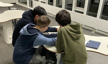 Drei Jungen arbeiten an einem iPad
