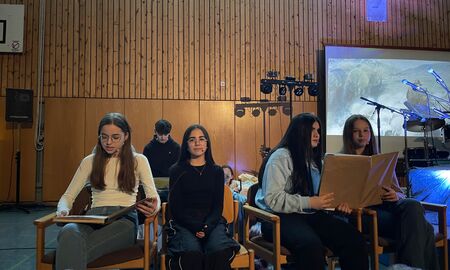 Ania, Carmen, Lina und Julia lesen den Zuhörern aus zwei großen Büchern die Geschichte "Die vier Lichter des Hirten Simon" vor.